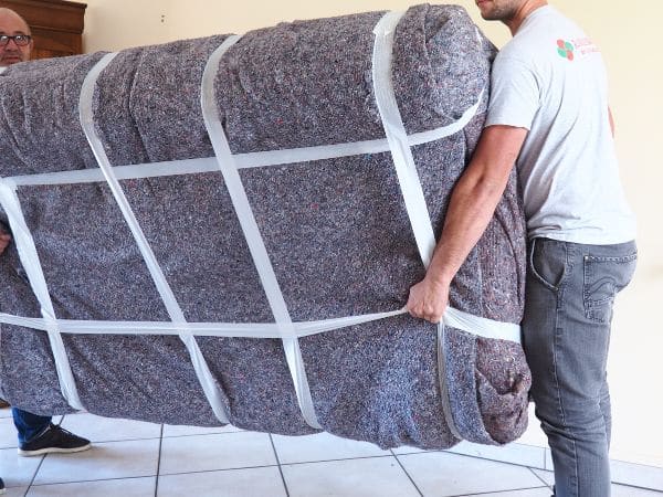 Exemple de transport de meubles : un canapé emballé sous couverture