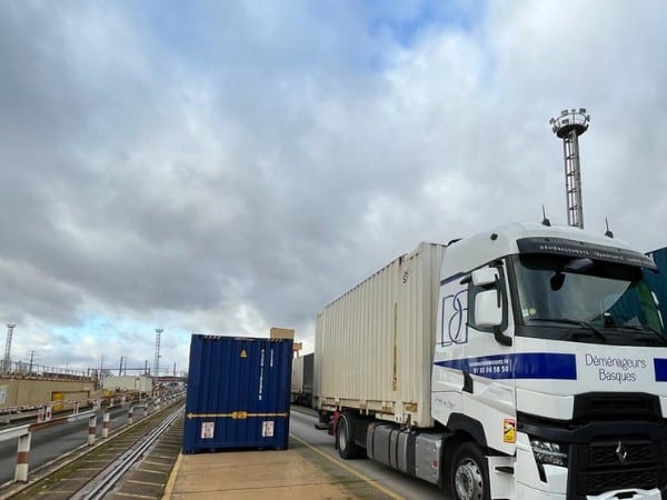 Camion de déménagement quittant une gare de fret SNCF avec un container dans le cadre d’un déménagement par train